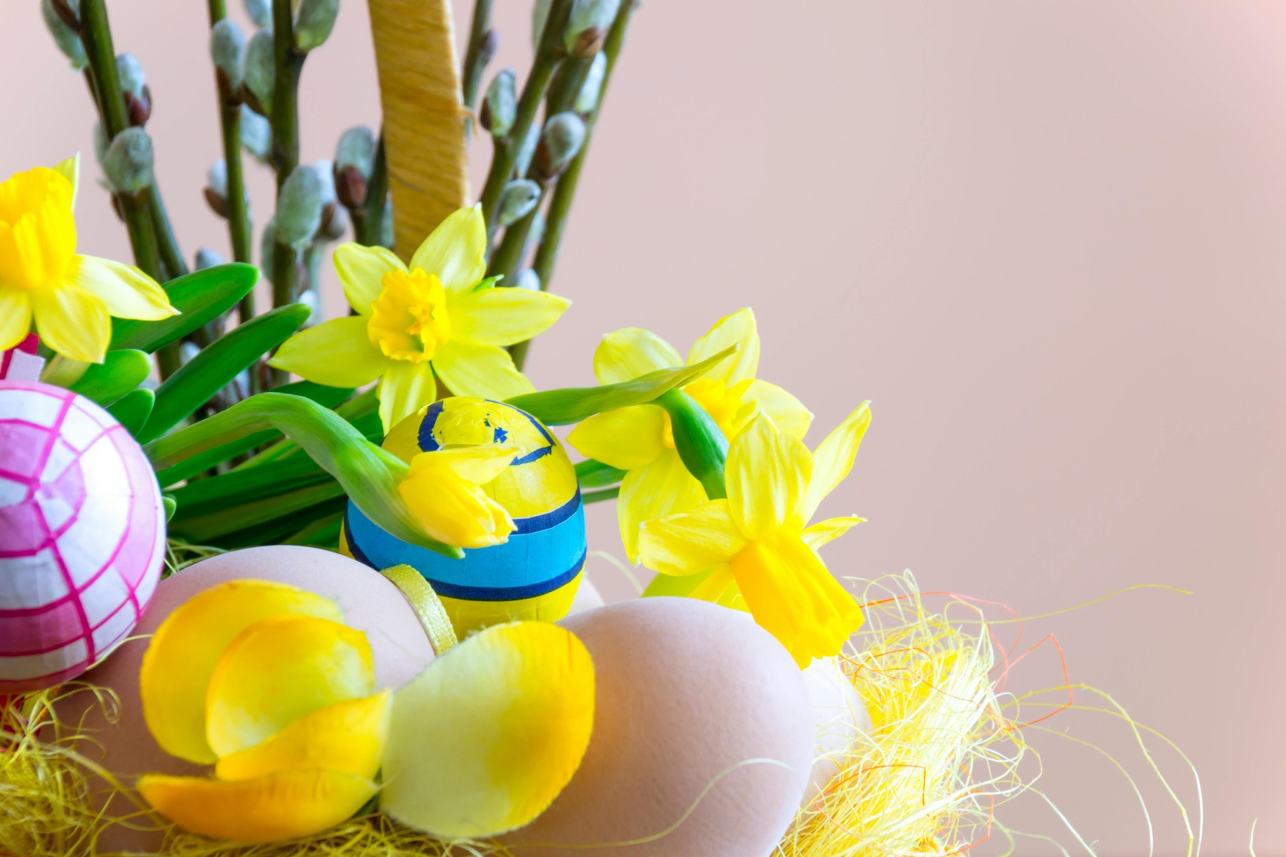 Frühlingshafte Osterdekoration mit Narzissen und bunten Eiern